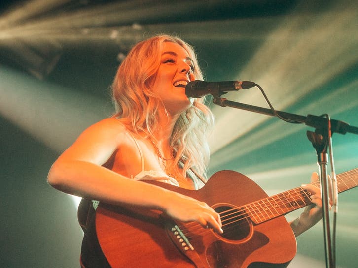 Lily Grace opening for Jackson Dean, showcasing her international reach and musical achievements.
